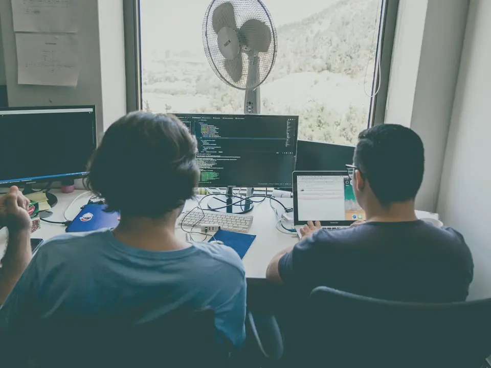 Two developers reviewing code on their screens